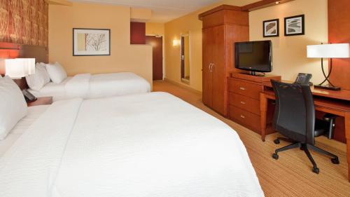 um quarto de hotel com duas camas e uma secretária e uma televisão em Courtyard by Marriott Pittsburgh North/Cranberry Woods em Cranberry Township