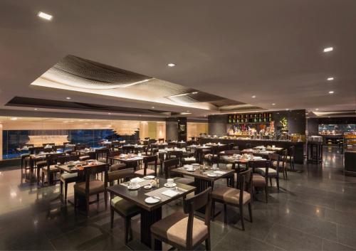 een restaurant met tafels en stoelen en een bar bij Crowne Plaza Kochi, an IHG Hotel in Cochin