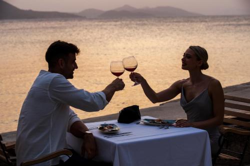 a man and woman sitting at a table with glasses of wine at TUI BLUE Kalamota Island - Adults Only in Dubrovnik