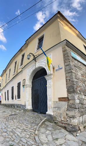 a building with a large door and a stone wall at Квартира у Старому місті in Kamianets-Podilskyi