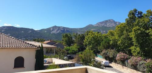 uma vista para uma casa com montanhas ao fundo em Très bel appartement,proche plage et centre ville. em Calvi