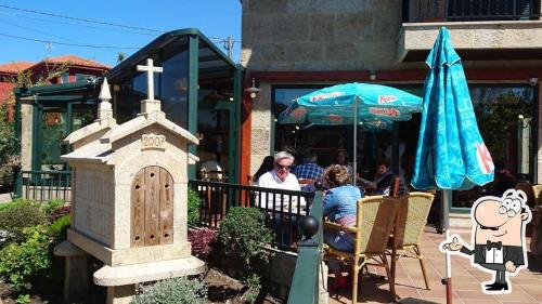 un groupe de personnes assises à une table à l'extérieur d'un restaurant dans l'établissement PENSION LUCERNA, à Vigo