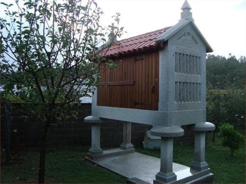 une maison pour oiseaux assise au-dessus d'une dalle en béton dans l'établissement PENSION LUCERNA, à Vigo