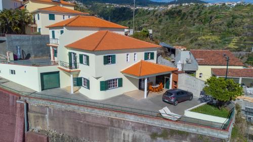 a large white house with an orange roof at Casa Vista Mar by GALMI in Calheta