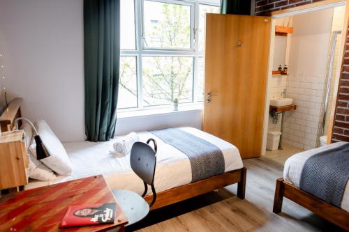 a small bedroom with a bed and a window at The Nest Boutique Hostel in Galway