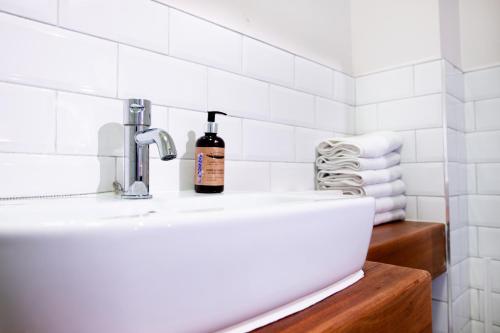 a bathroom sink with a bottle of soap on it at The Nest Boutique Hostel in Galway