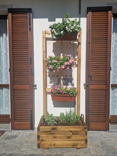 une exposition de fleurs dans une boîte en bois devant un bâtiment dans l'établissement Lake mood holiday home, à Cadrezzate