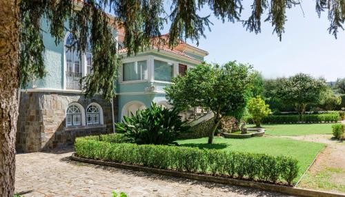 ein blaues Haus mit einem Baum davor in der Unterkunft Torres da Vila in Anadia