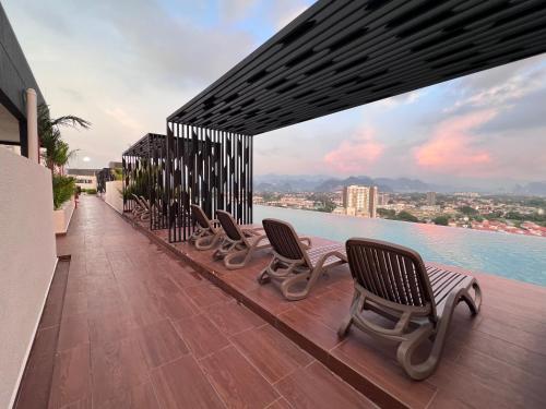 una fila de sillas sentadas en una terraza con vistas al agua en The Horizon - Ipoh, en Ipoh