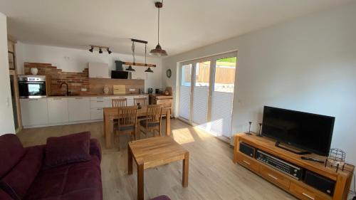 a living room with a couch and a tv and a kitchen at Klönhüsing in Altefähr