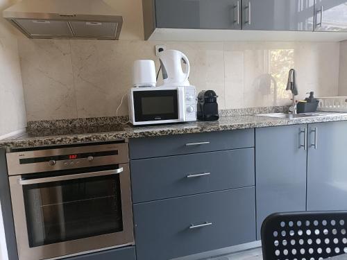 a kitchen with a microwave and a counter top at Guesthouse Monsanto in Porto