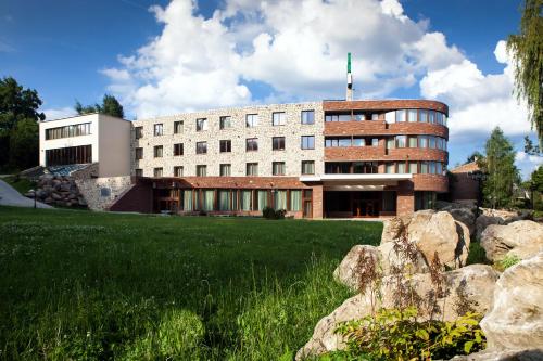 um edifício com um campo verde à sua frente em Hotel Royal Botanic em Lublin