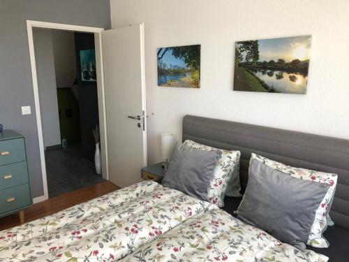 a bedroom with a bed and two paintings on the wall at Gästezimmer Erlinsbach bei Aarau, zwischen Aare und Jura in Niedererlinsbach