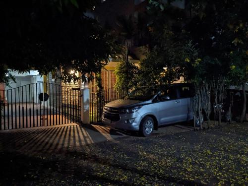 un'auto parcheggiata di notte di fronte a una recinzione di Athreyas@60/A a Mysore