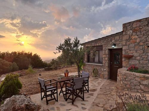 un patio con mesa y sillas frente a un edificio en Ηλιοβασίλεμα, en Chios