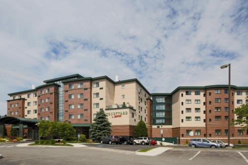 un grand bâtiment avec des voitures garées dans un parking dans l'établissement Courtyard by Marriott Boston Waltham, à Waltham