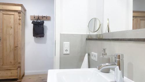 a white bathroom with a sink and a mirror at Apartments am Dom in Naumburg