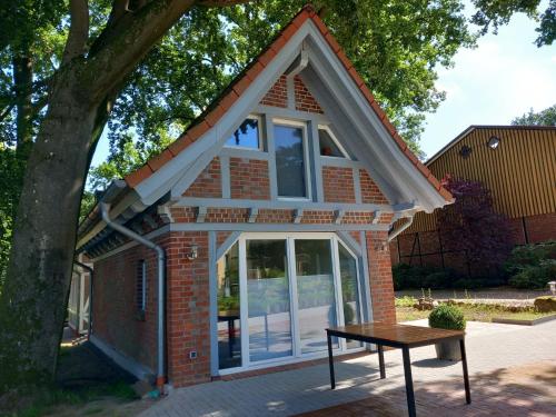 een tiny house met een schuin dak en een tafel bij Ferienhaus Heidenest, E-Bike, Bettwäsche und Handtücher zubuchbar in Buchholz in der Nordheide