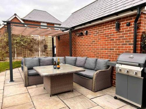 a patio with a table and chairs and a grill at Snowdonia Retreat in Bangor