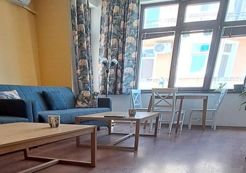 ein Wohnzimmer mit einem Sofa, Tischen und Stühlen in der Unterkunft Ivory Tower Hostel in Sofia