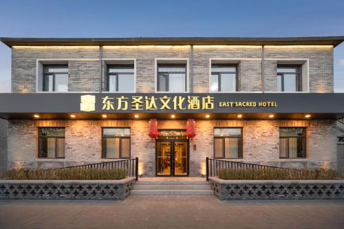 East Sacred Hotel ᴸᴱO---Foreign Accept---Two minutes walk to Subway 丨Tourism Service English-speaking 丨 Near Tiananmen Forbidden City丨European foot ball English丨Free Advance tickets and Laundry Drying service coffee snacks في بكين: مبنى عليه لافته مكتوب عليها فندق firstario