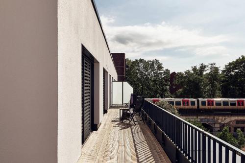 un bâtiment avec balcon et train sur les pistes dans l'établissement Arbio I Makro Apartments, à Hambourg