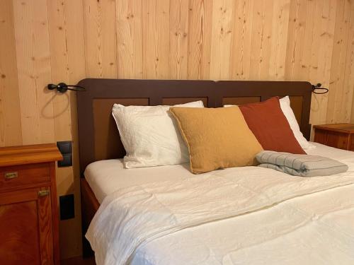 un letto con lenzuola e cuscini bianchi di Schallerhof Sterzing - Deine Auszeit mit Ausblick in unseren Ferienwohnungen auf dem Bergbauernhof in Südtirol a Vipiteno