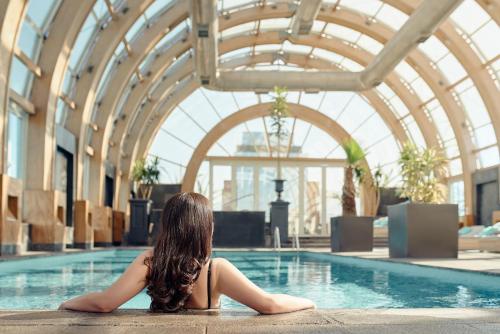 uma menina sentada numa piscina em The Ritz-Carlton, Santiago em Santiago