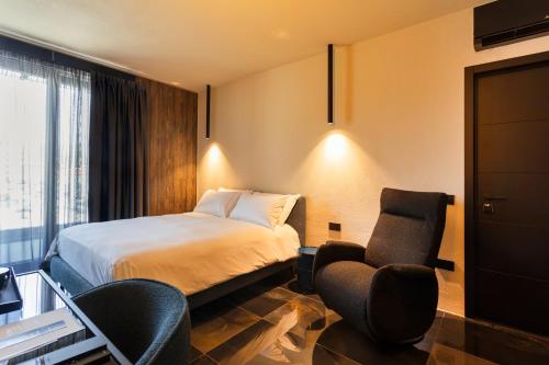 una camera d'albergo con un letto e due sedie di Etrus - Boutique Room & Rooftop a Pontecagnano