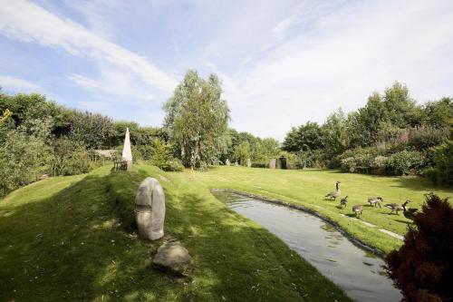 um campo com um rio e um grupo de animais em The Manor at Plane Castle em Falkirk