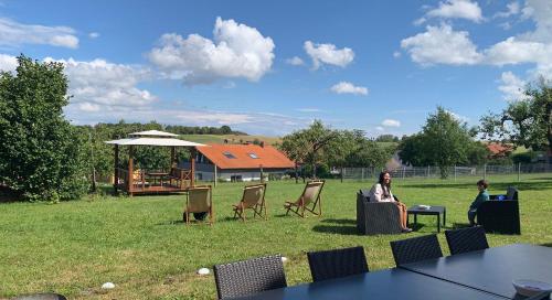 twee mensen aan een tafel in een veld bij Ferienhaus Liebchen free Netflix in Freienhagen