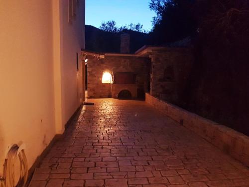 eine leere Gasse in der Nacht mit Licht an der Wand in der Unterkunft Σπίτι με θέα in Nafpaktos