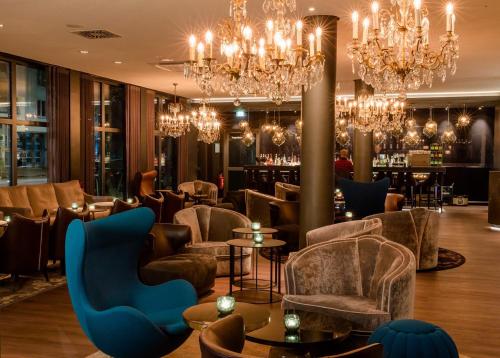 a hotel lobby with chandeliers and a bar at Motel One Berlin-Bellevue in Berlin