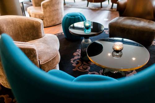 a living room with couches and a table and chairs at Motel One Berlin-Bellevue in Berlin