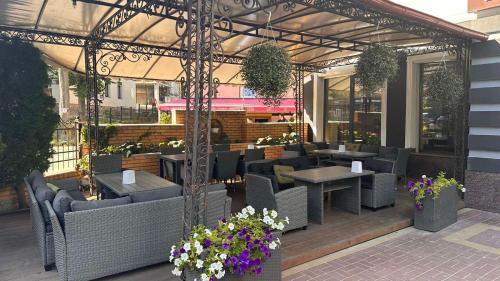 a restaurant with couches and tables and flowers at Richky Hotel in Truskavets