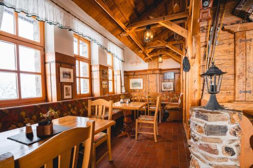 een restaurant met houten muren en tafels en ramen bij Fichtelberghaus in Kurort Oberwiesenthal