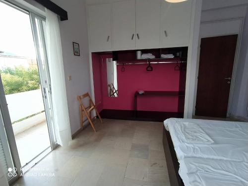 ein Schlafzimmer mit einem Bett und einer rosa Wand in der Unterkunft Dimitropoulos Apartments in Eleonas