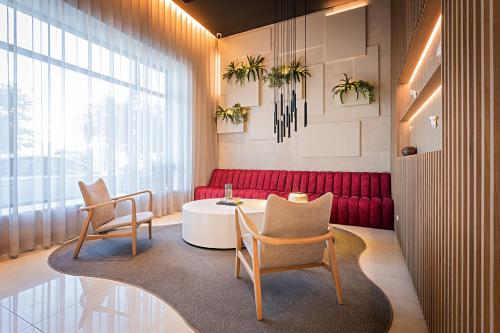 a living room with a red couch and two chairs at Hotel Canada in Lisbon