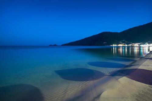 una vista de un cuerpo de agua por la noche en ILIORAMA LUXURY SUITES, en Skala Potamias