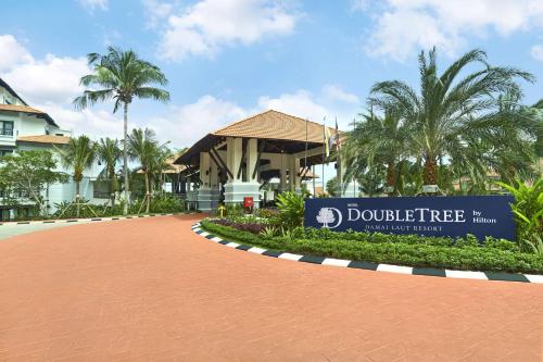 DoubleTree by Hilton Damai Laut في لوموت: لافته امام عماره فيها نخيل