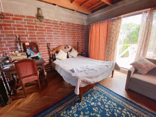 a bedroom with a bed and a brick wall at 猫とピアノと星空のリゾートブティックコテージ - Starry Forest Cottage Okinawa - in Onna