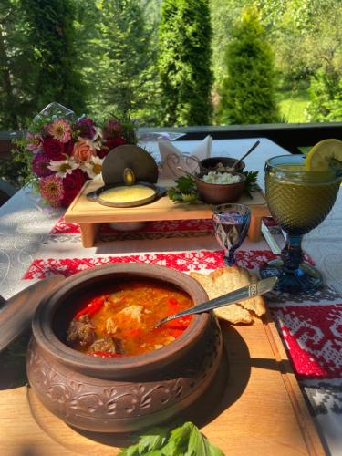 uma mesa com uma tigela de sopa e outra comida em Hotel Tys em Dilove