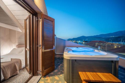 un balcone con un bagno con lavandino e un letto di Pink Panther Maisonette Suite ad Argostoli