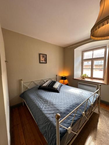 1 dormitorio con 1 cama con edredón azul y ventana en Baznīcas ielas apartamenti, en Kuldīga