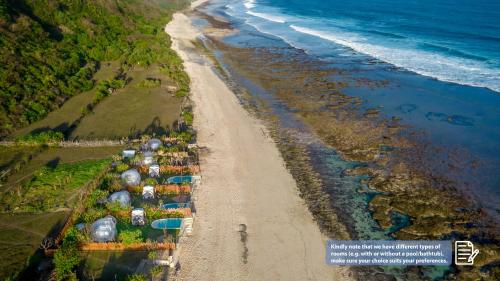 una vista aérea de una playa con tiendas de campaña y el océano en Bubble Hotel Nyang Nyang - Adults only, en Uluwatu