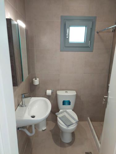 a bathroom with a toilet and a sink at Eri Hotel in Parikia