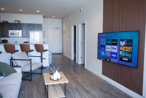 uma sala de estar com uma televisão de ecrã plano na parede em Entire High-Rise Apartment - 2BD em Baton Rouge