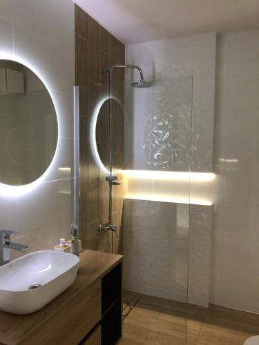 y baño con lavabo y ducha acristalada. en Apartament Patio Vita -garaż podziemny, taras,wejście klamka kod,centrum, en Kielce