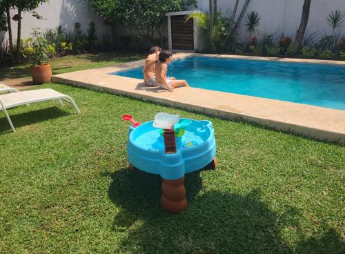 um homem e uma mulher sentados ao lado de uma piscina em Hermosa casa en Cuernavaca cerca de los mejores restaurantes y plazas em Cuernavaca