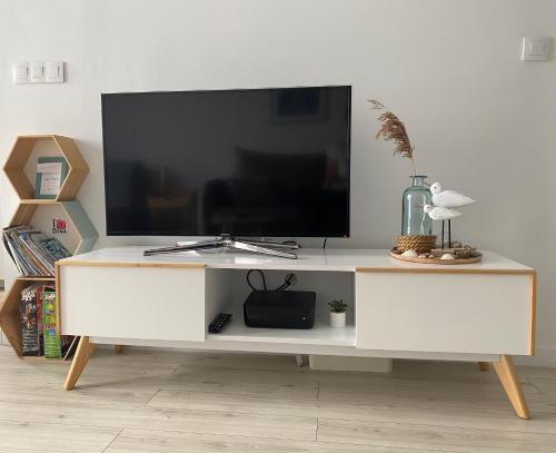 un centro di intrattenimento bianco con TV a schermo piatto di Apartament Horizon a Gdynia